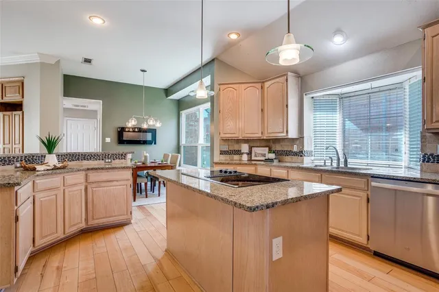 a kitchen with stainless steel appliances granite countertop a sink a stove and refrigerator