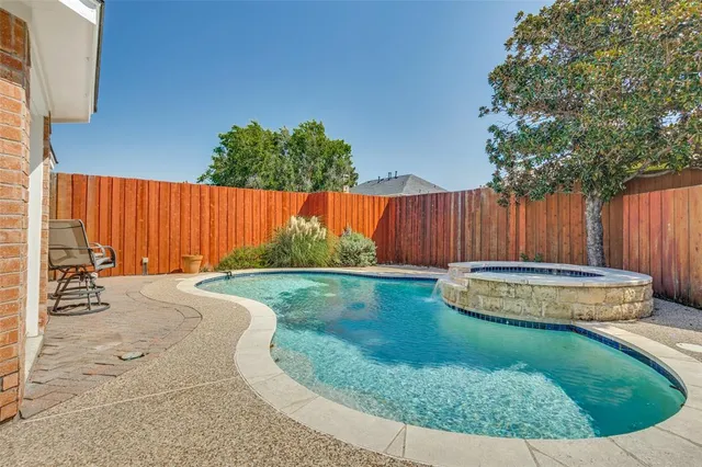 a view of a backyard with a barbeque and wooden fence