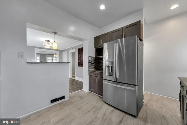 a kitchen with granite countertop stainless steel appliances a refrigerator and a sink
