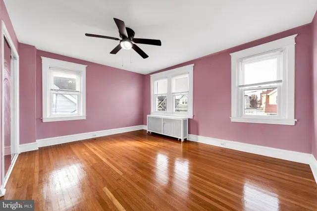 a view of empty room with wooden floor and window