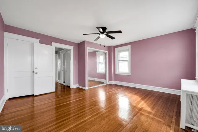 a view of an empty room with window and wooden floor