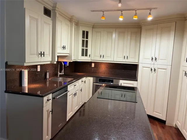 a kitchen with granite countertop a sink and a stove top oven