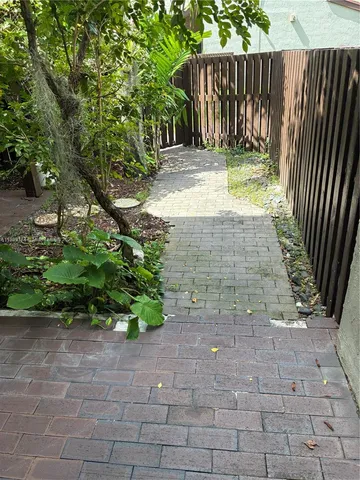 a view of garden with wooden fence