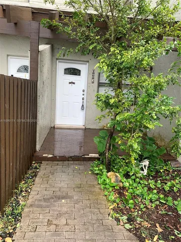 a view of a pathway of a house with potted plants