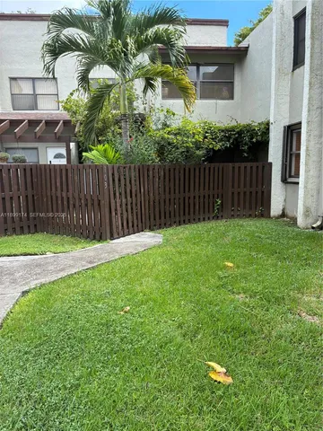 a view of a backyard with wooden fence
