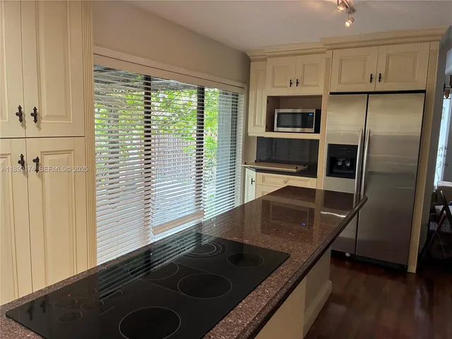 a kitchen with stainless steel appliances granite countertop a sink and a refrigerator