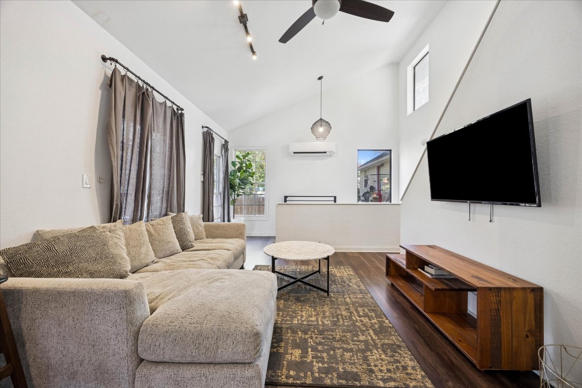 604 Pressler Street Austin, TX 78703 - Photo 16 of 40 Living area featuring dark wood-style floors, high vaulted ceiling, a ceiling fan, rail lighting, and a wall mounted air conditioner