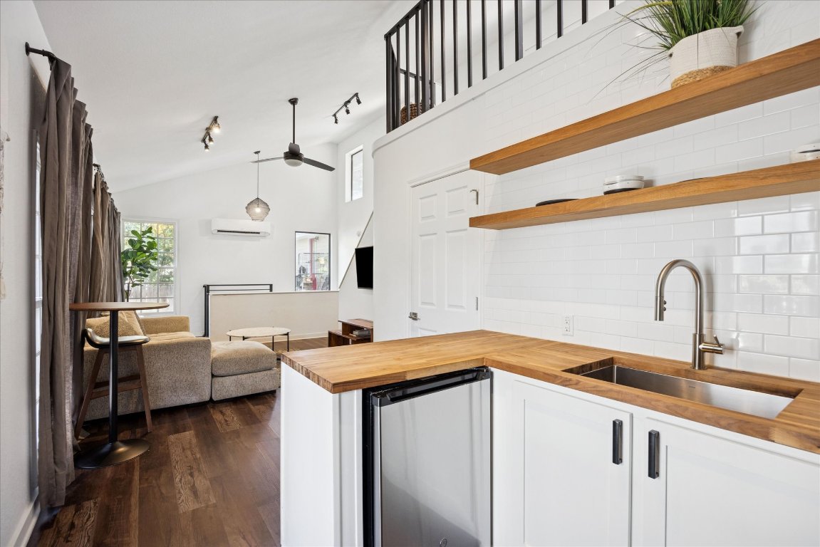 604 Pressler Street Austin, TX 78703 - Photo 18 of 40 Kitchen with butcher block counters, decorative backsplash, stainless steel fridge, white cabinets, and vaulted ceiling