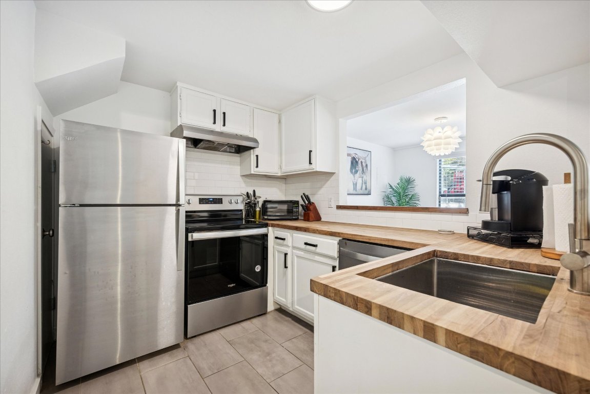 604 Pressler Street Austin, TX 78703 - Photo 28 of 40 Kitchen with butcher block counters, stainless steel appliances, white cabinetry, and decorative backsplash