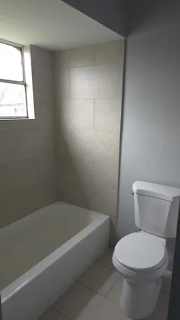 a white toilet sitting next to a bath tub
