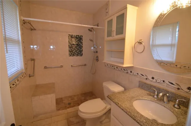 a bathroom with a granite countertop sink toilet and shower