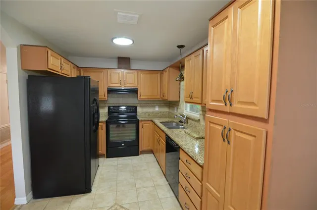a kitchen with granite countertop cabinets and refrigerator