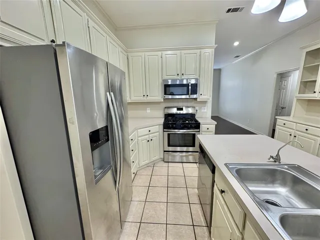 a kitchen with stainless steel appliances a refrigerator sink and stove