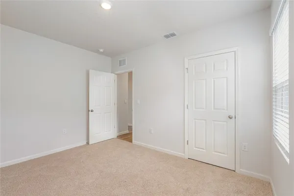 an empty room with windows and closet area