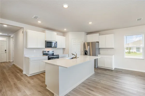 a kitchen with white cabinets and stainless steel appliances