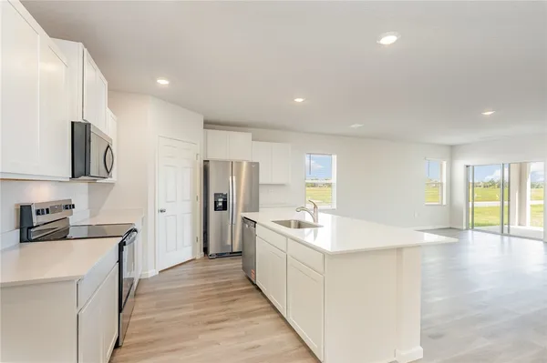 a large white kitchen with stainless steel appliances