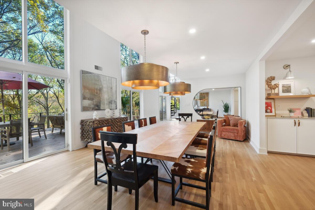 11900 Viewcrest Terrace Silver Spring, MD 20902 - Photo 22 of 69 a view of a dining room and livingroom with furniture wooden floor a rug a flat screen tv a painting and a chandelier