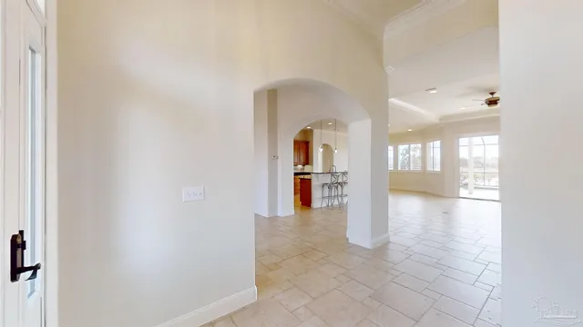 a view of a hallway with windows and chandelier