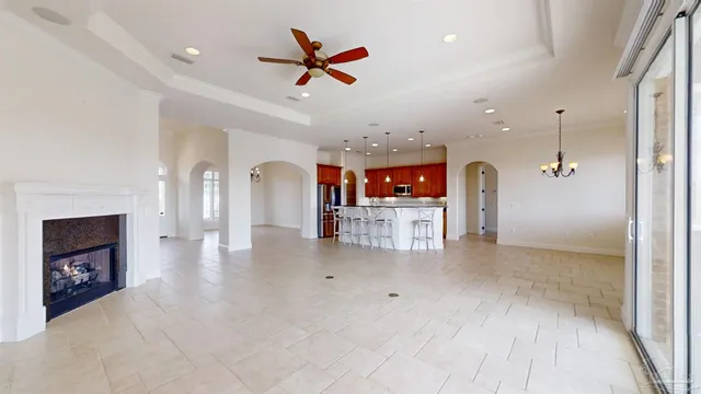 a view of a dining room and livingroom with furniture wooden floor a chandelier