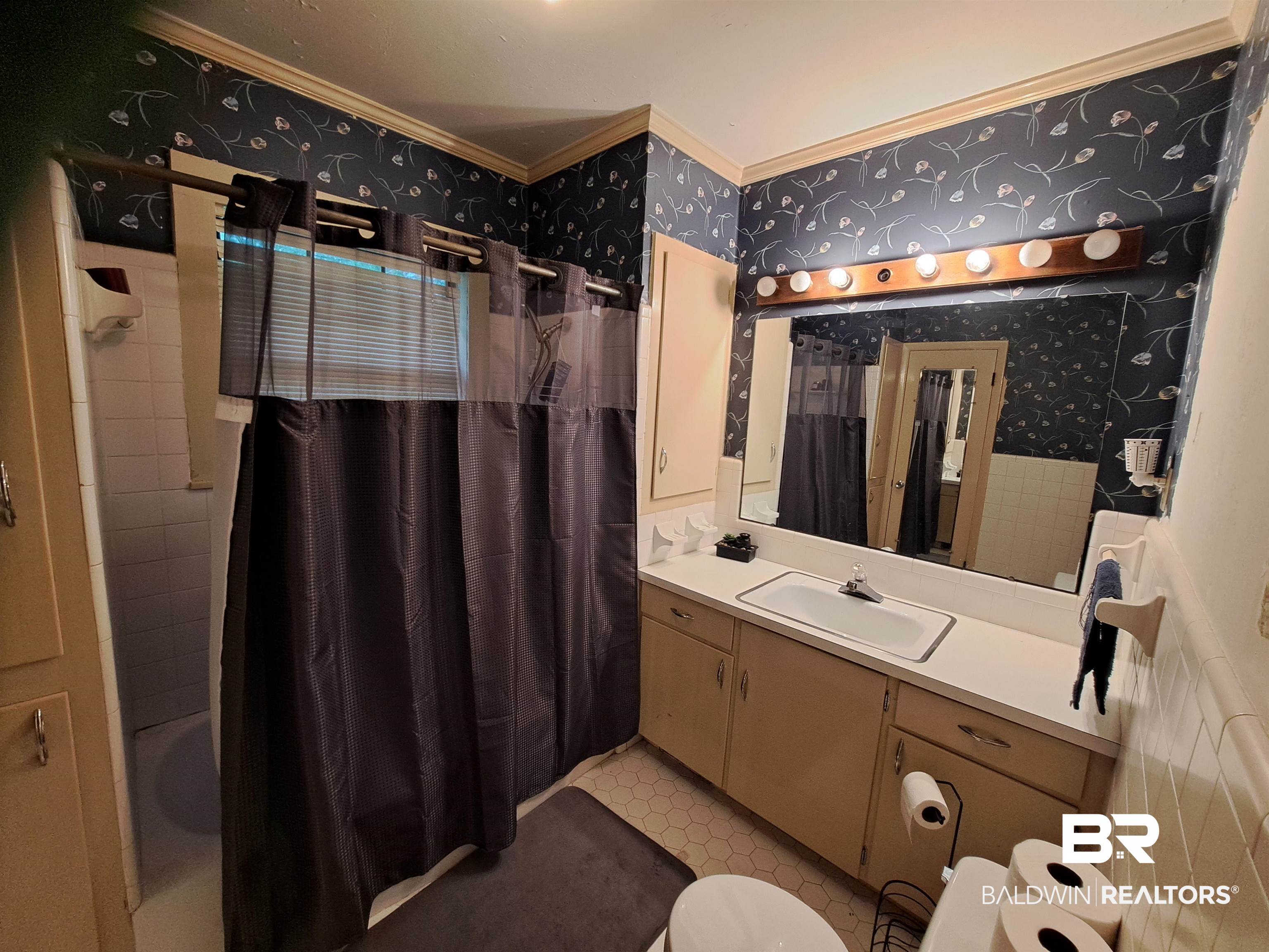 309 Bellview Avenue Evergreen, AL 36401 - Photo 21 of 27 Full bath with wallpapered walls, shower / bathtub combination with curtain, vanity, crown molding, and tile walls