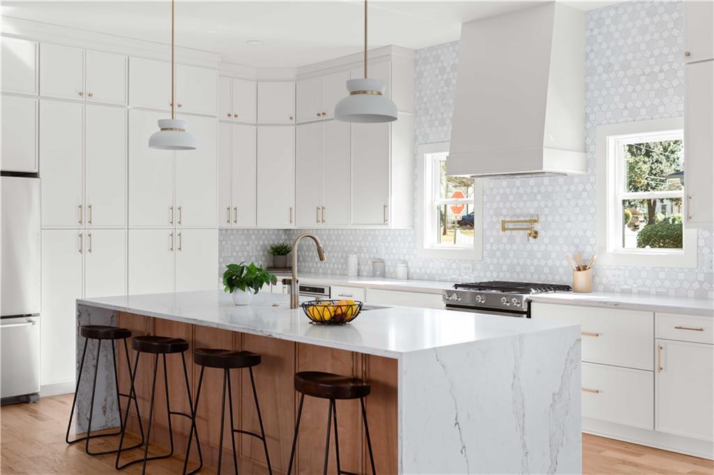 286 Sisson Avenue Northeast Atlanta, GA 30317 - Photo 12 of 56 a kitchen with a sink a stove a white cabinets and a window