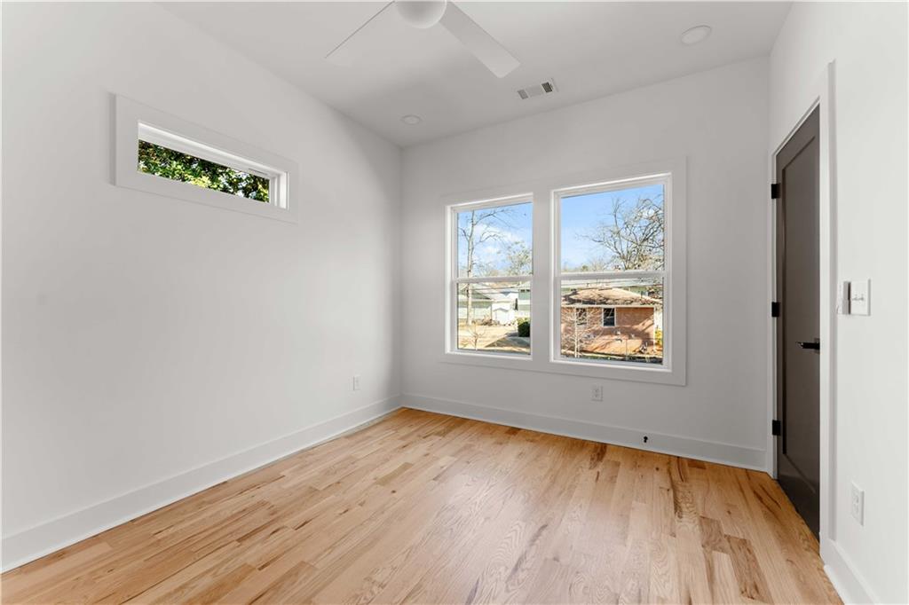 286 Sisson Avenue Northeast Atlanta, GA 30317 - Photo 27 of 56 an empty room with a window and wooden floor