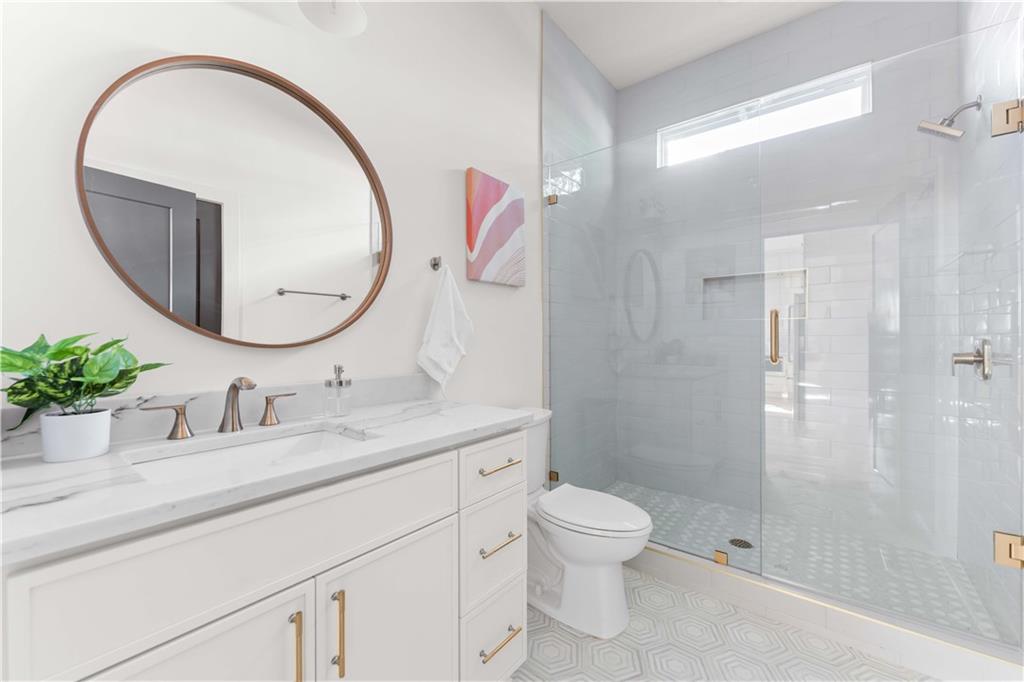 286 Sisson Avenue Northeast Atlanta, GA 30317 - Photo 9 of 56 a bathroom with a sink a mirror a toilet and shower