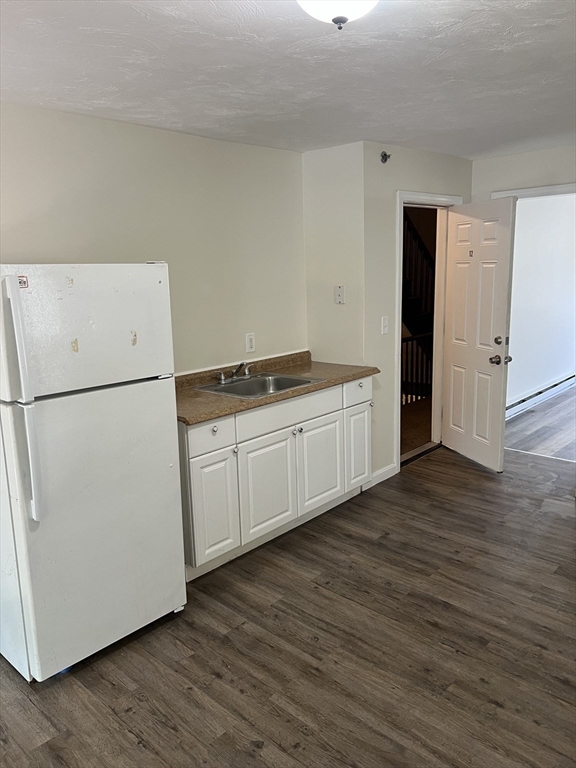 12 Aspen Street Ware, MA 01082 - Photo 3 of 17 a kitchen with white cabinets and white appliances