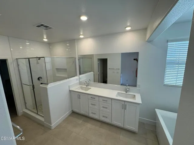 a bathroom with a double vanity sink and mirror