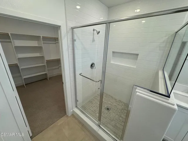 a bathroom with a shower and a glass door