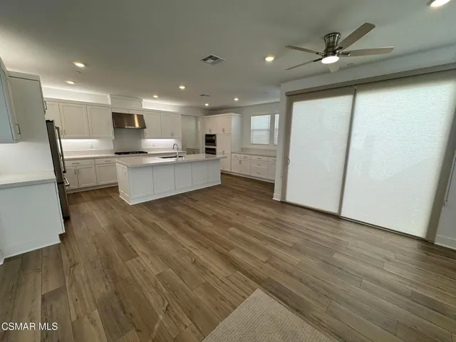 a large white kitchen with wooden floors and a fireplace