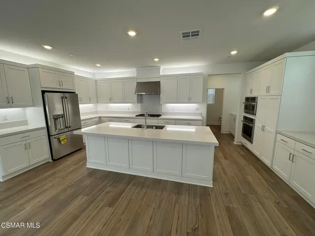 a kitchen with stainless steel appliances a refrigerator sink and cabinets