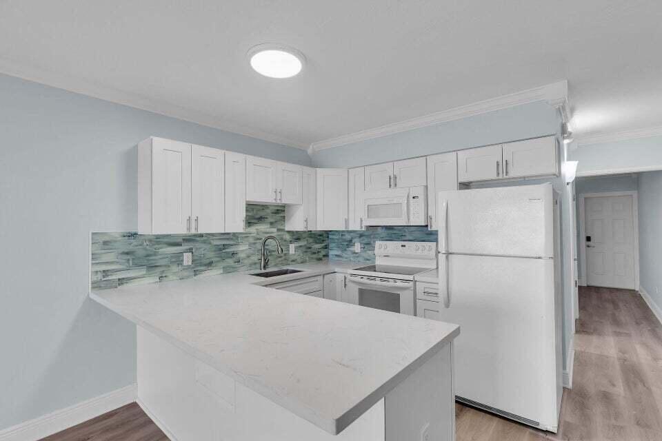300 Duck Key Drive, Unit 9 Duck Key, FL 33050 - Photo 4 of 22 a kitchen with a refrigerator a stove top oven a sink and white cabinets