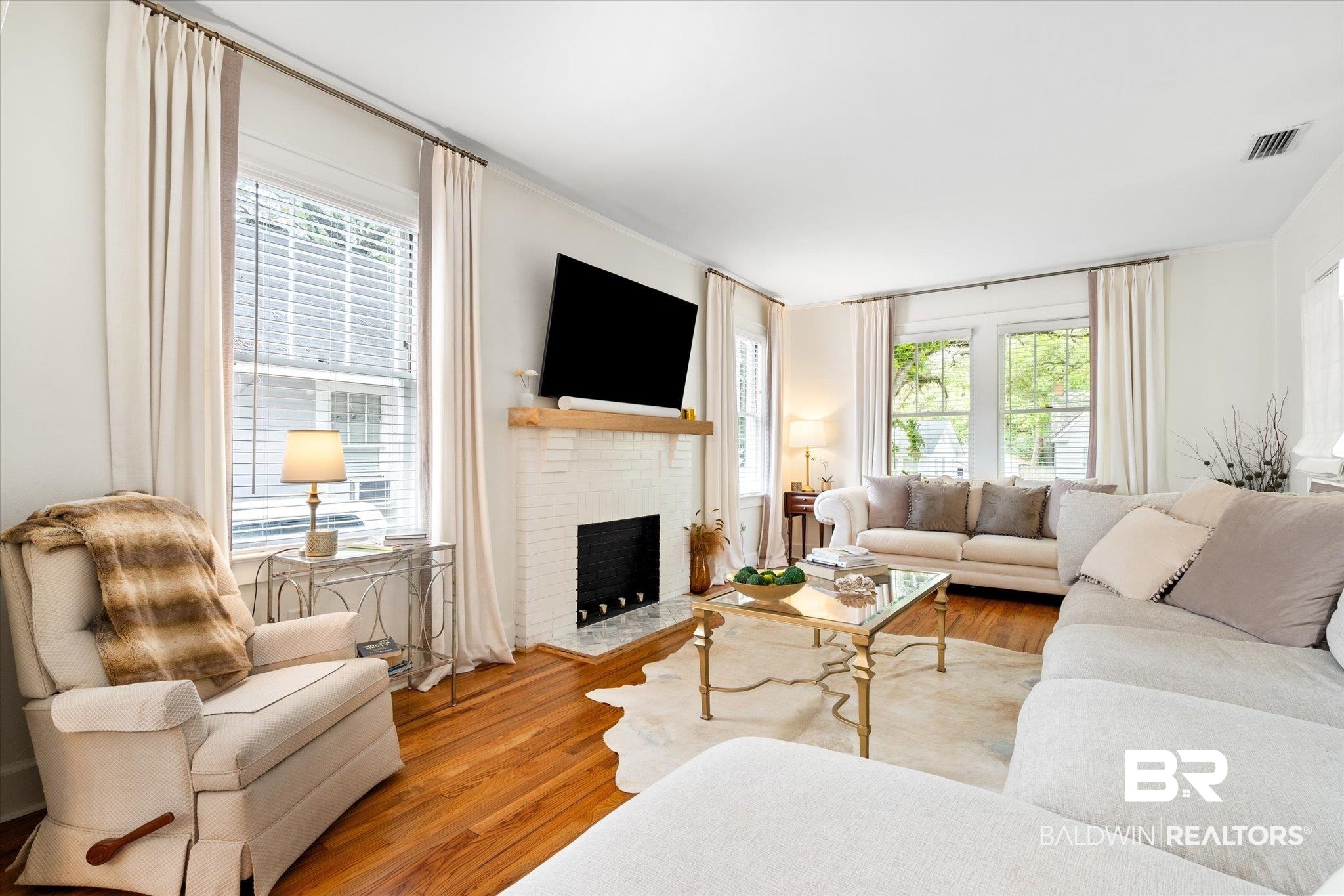 112 Crenshaw Street Mobile, AL 36606 - Photo 6 of 21 Living area featuring wood finished floors, a brick fireplace, and plenty of natural light