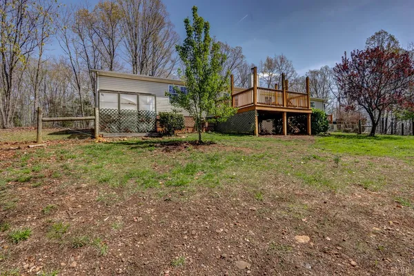a backyard of a house with plants and large tree
