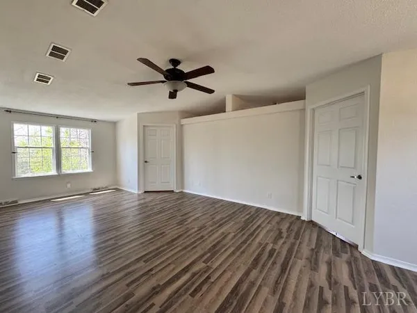 a large kitchen with a large counter top space a refrigerator and wooden cabinets