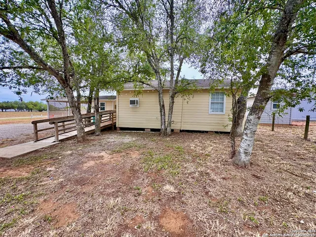 a view of a house with backyard and tree