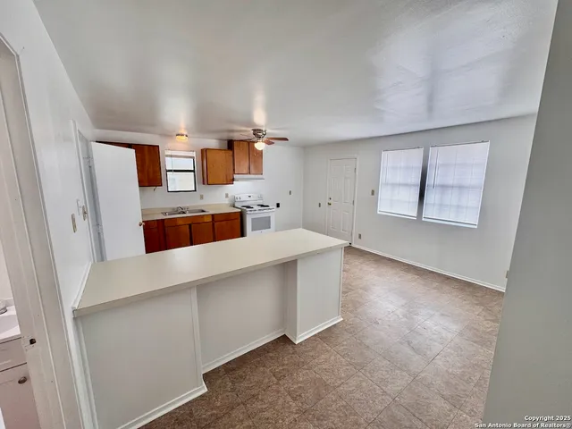 walk in closet with view of kitchen and window