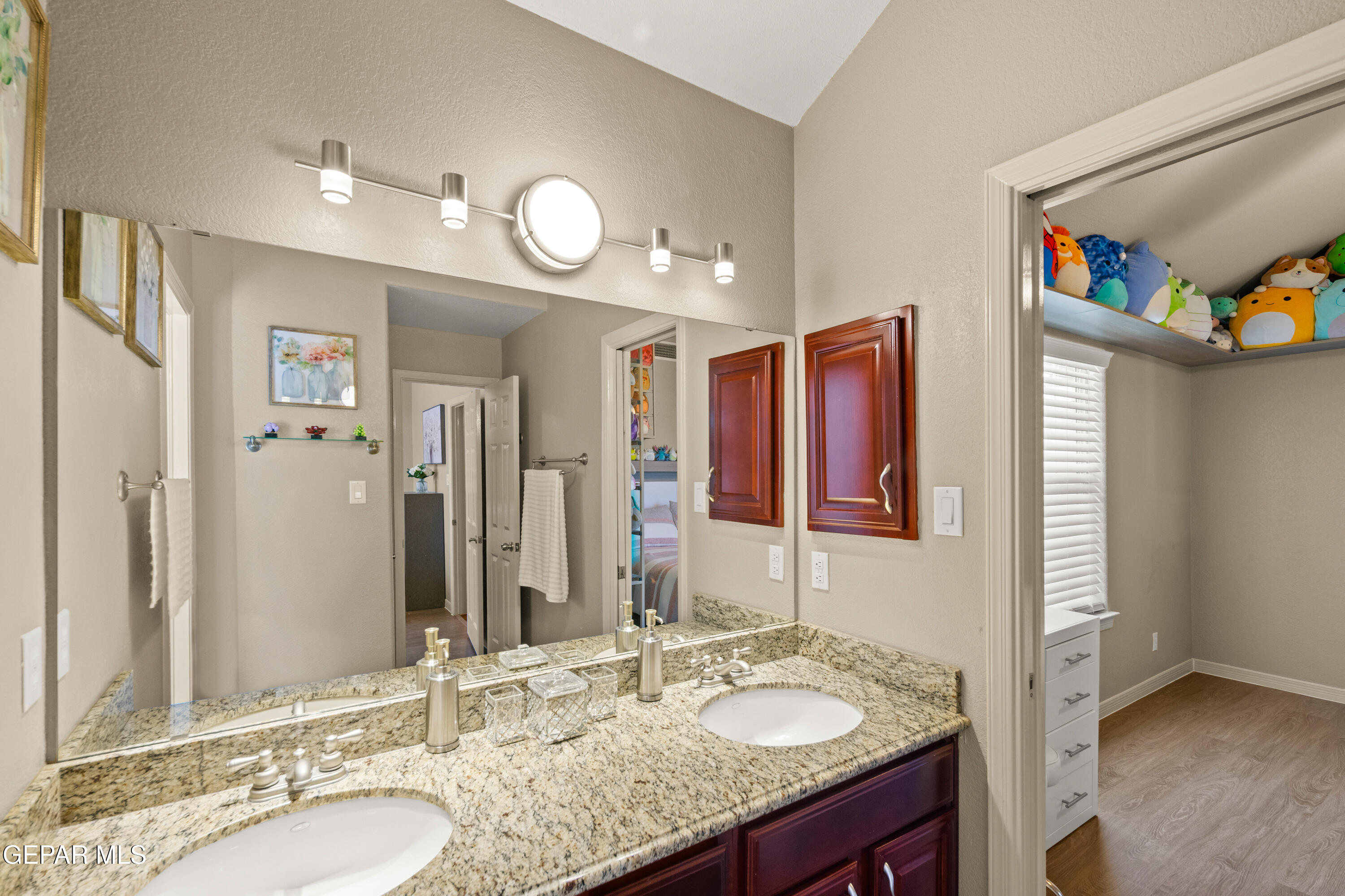6705 Pearl Ridge Drive El Paso, TX 79912 - Photo 34 of 58 a bathroom with a granite countertop double vanity sink and a mirror