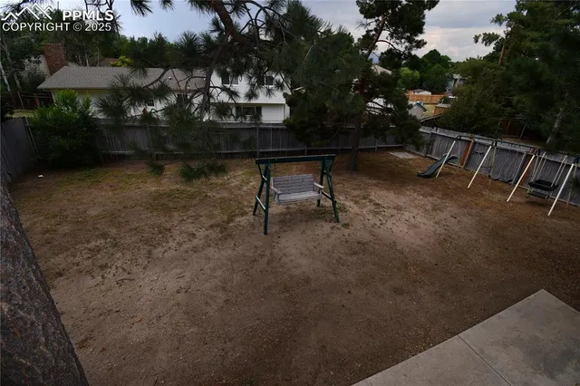 a view of a backyard with a wooden fence