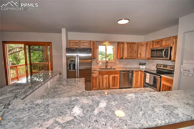 a kitchen with stainless steel appliances granite countertop a stove sink and refrigerator