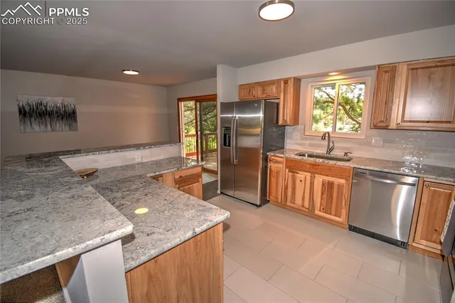 a kitchen with stainless steel appliances granite countertop a sink a stove and a refrigerator