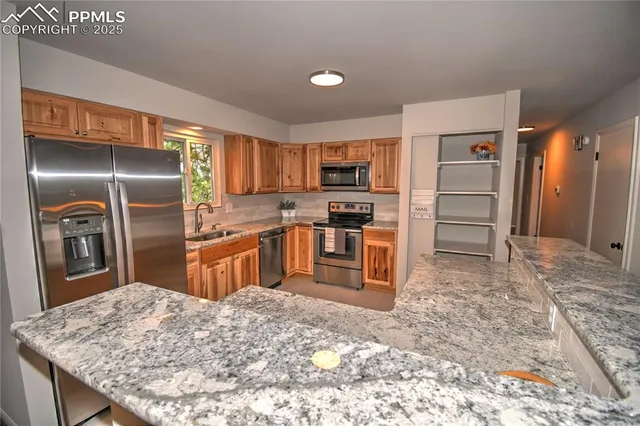 a kitchen with granite countertop a refrigerator and a sink