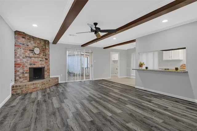 a view of empty room with wooden floor and fireplace