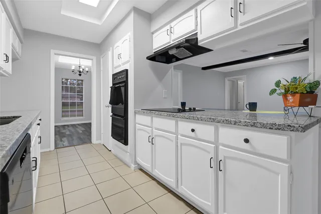 a kitchen with white cabinets and appliances
