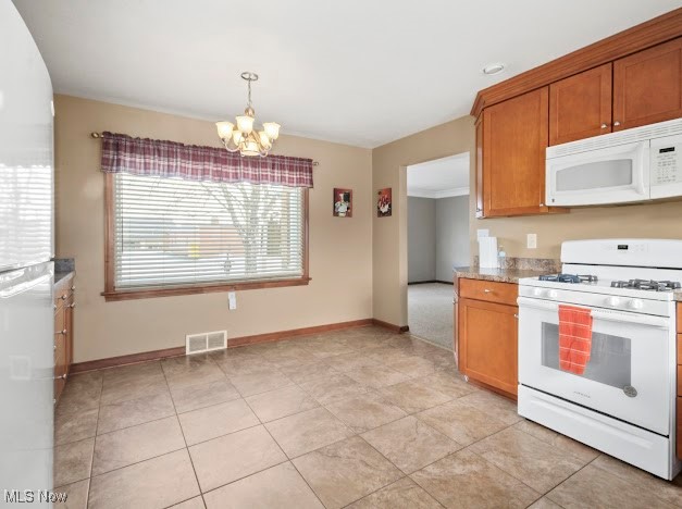 284 Wilson Street Struthers, OH 44471 - Photo 5 of 16 Kitchen with white appliances, a chandelier, brown cabinetry, decorative light fixtures, and light stone counters