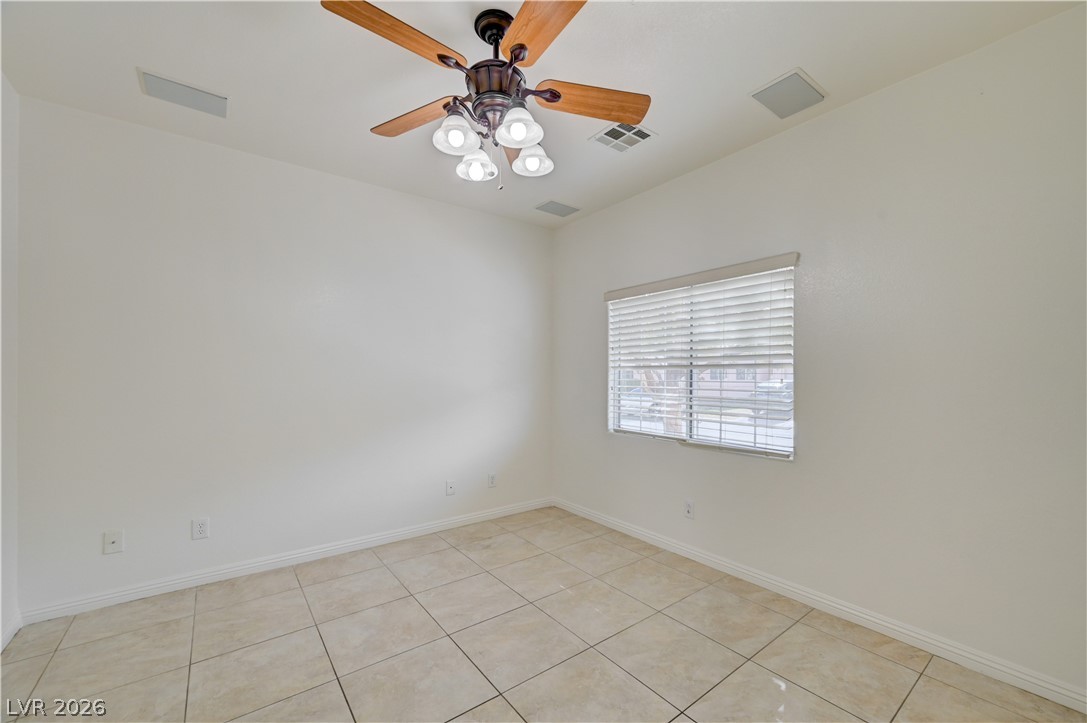 8918 Houston Ridge Avenue Las Vegas, NV 89178 - Photo 9 of 35 A well-lit space features tile flooring and a ceiling fan with integrated lighting.
