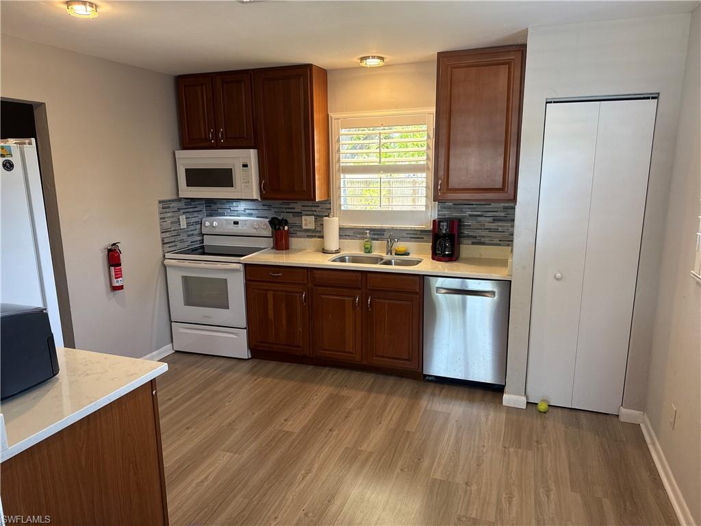 5422 Hardee Street Naples, FL 34113 - Photo 2 of 16 a kitchen with stainless steel appliances a sink a stove a refrigerator and cabinets