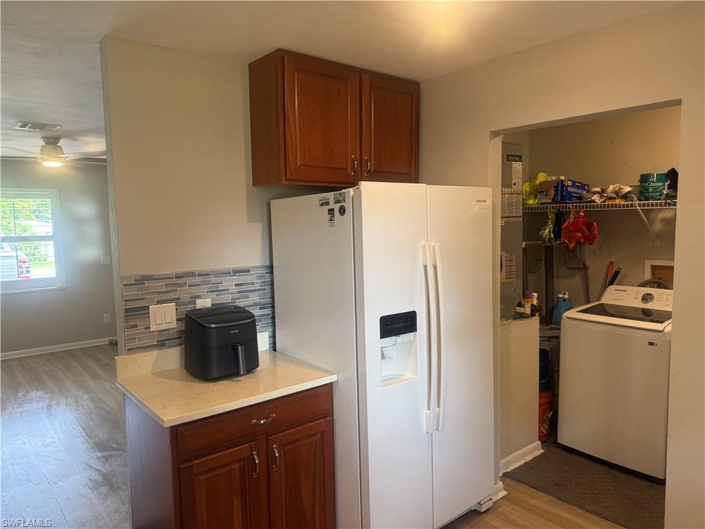 5422 Hardee Street Naples, FL 34113 - Photo 3 of 16 a kitchen with a refrigerator a stove and wooden floor