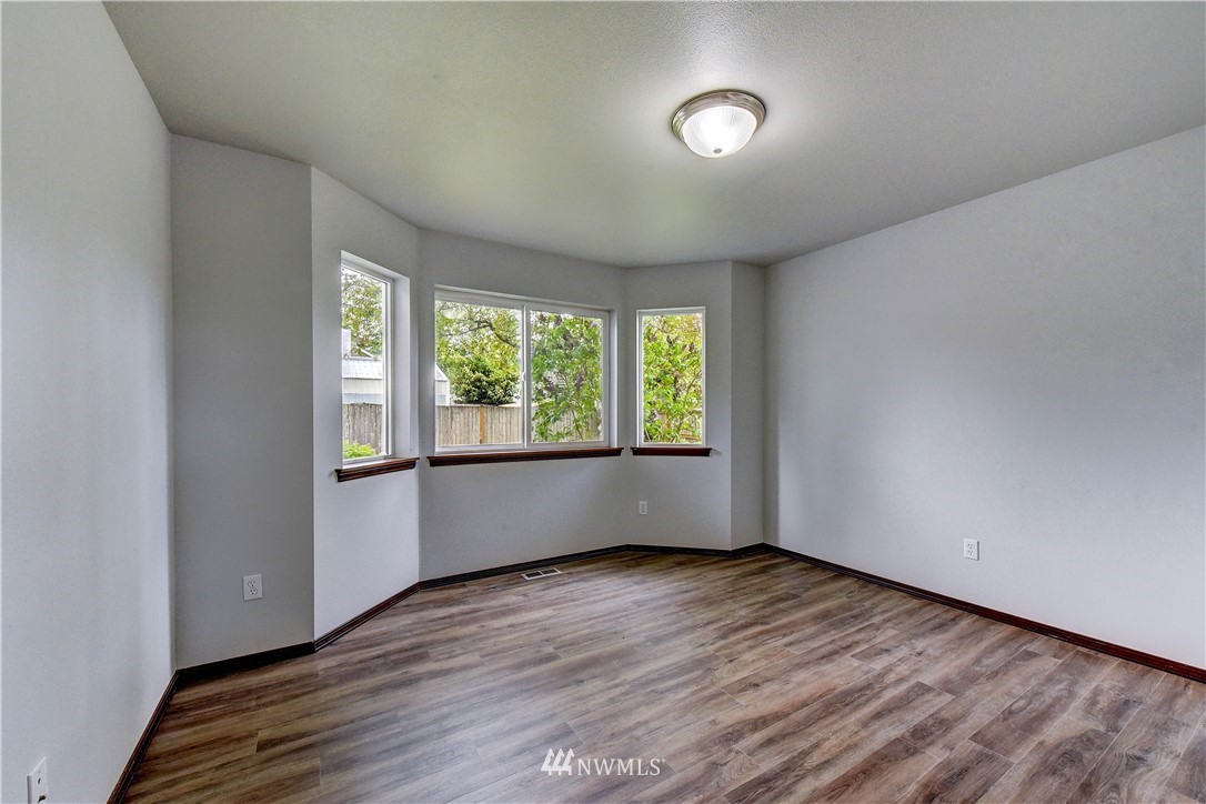 6605 Cady Road Everett, WA 98203 - Photo 21 of 26 an empty room with wooden floor and windows